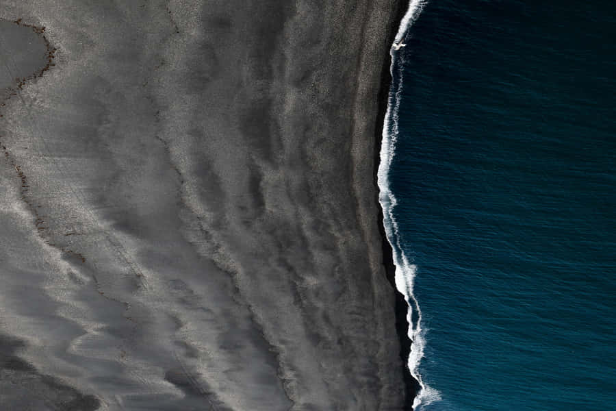 Revel In The Majesty Of A Black Sand Beach. Wallpaper