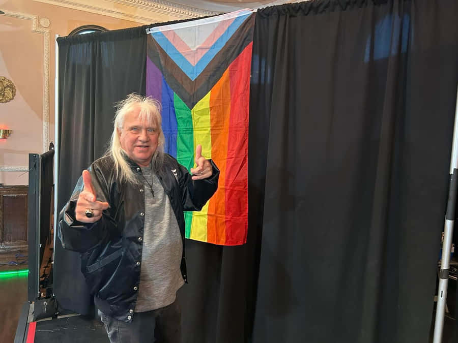 Ricky Morton Posing With Lgbtq Pride Flag Wallpaper