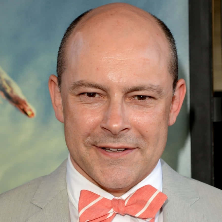 Rob Corddry Smiles With A Bright Beach Backdrop Wallpaper