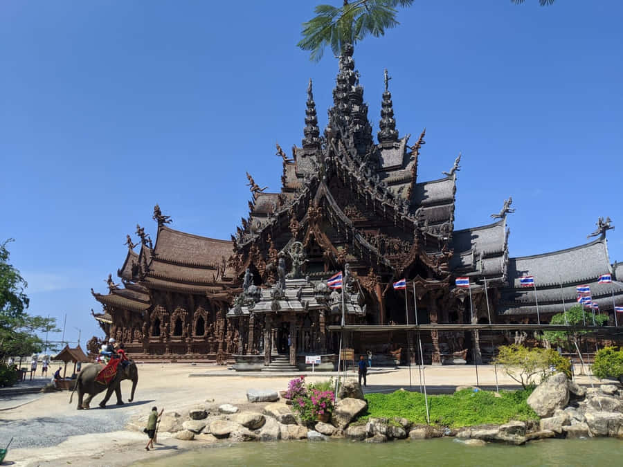 Sanctuary Of Truth Beneath Blue Sky In Thailand Wallpaper