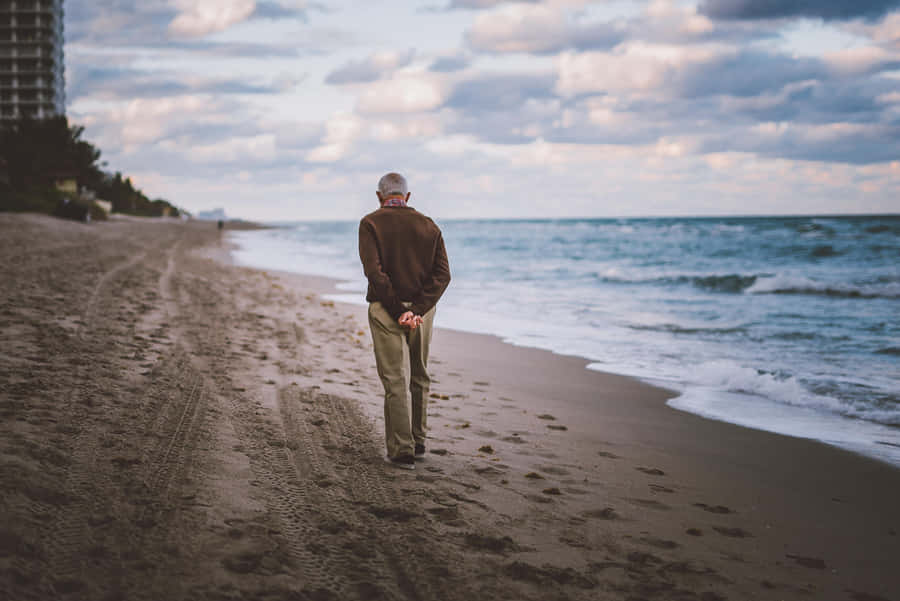 Serene Beach Walk At Sunset Wallpaper