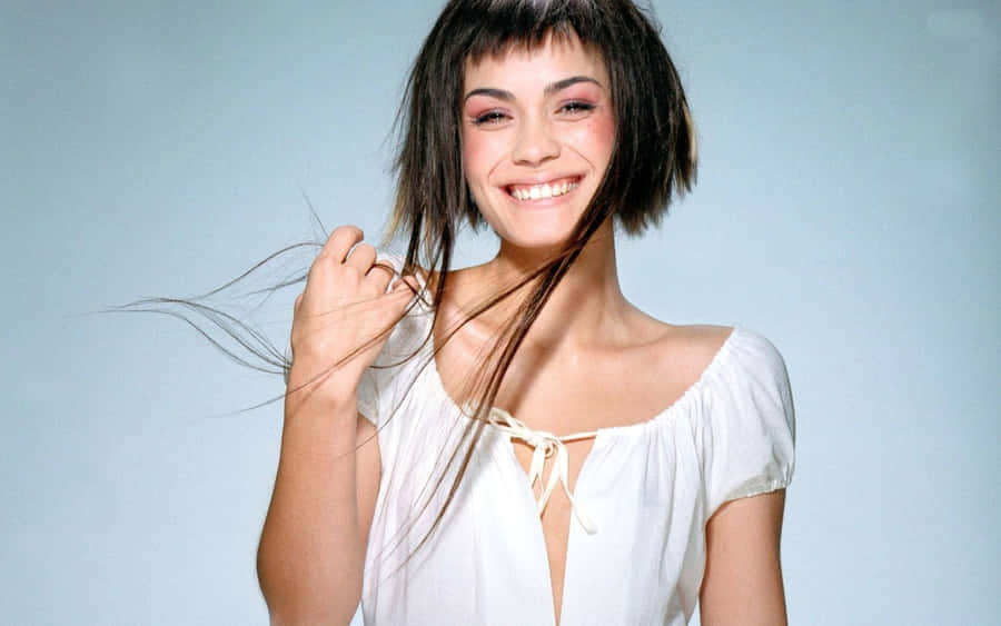 Shannyn Sossamon Posing In Red Dress Against Rustic Wooden Background Wallpaper