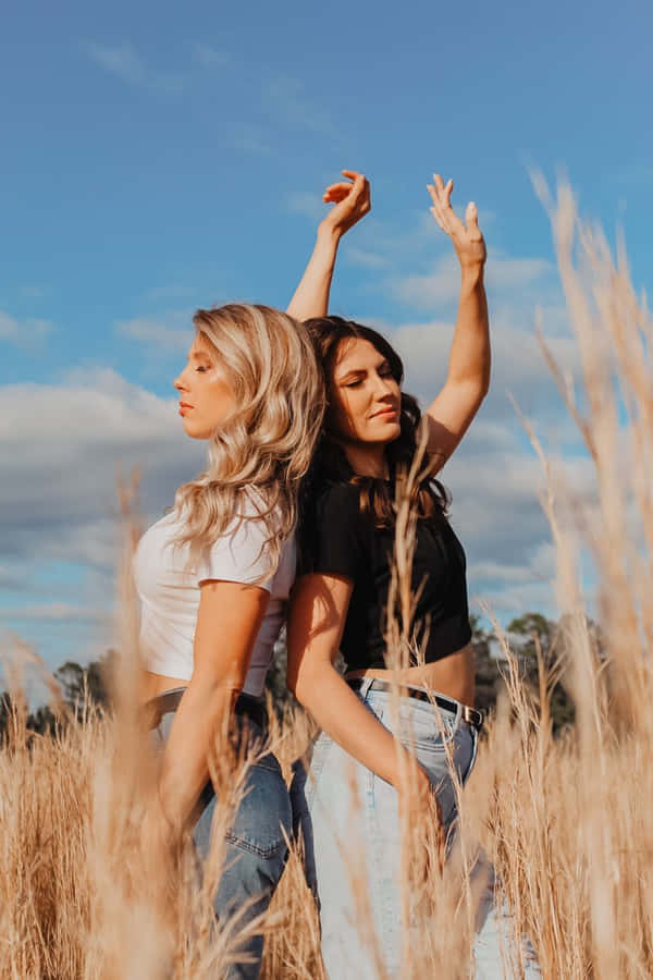 Sisters_ Embracing_in_ Sunny_ Field.jpg Wallpaper