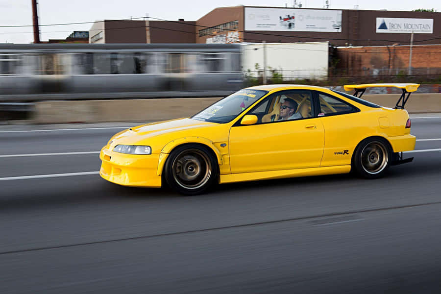 Sleek Acura Integra Speeding Down The Road Wallpaper