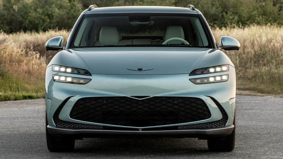 Sleek And Luxurious Genesis Gv60 Electric Suv On The Road Wallpaper
