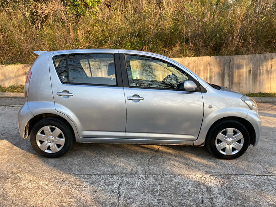 Sleek And Stylish Daihatsu Sirion In Cityscape Wallpaper