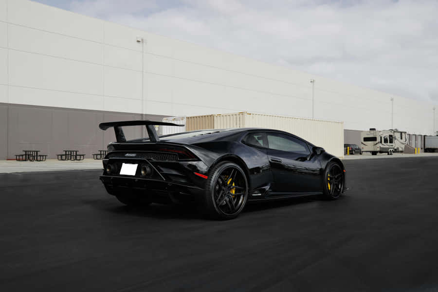 Sleek_ Black_ Sports_ Car_ Parked_ Outdoors.jpg Wallpaper