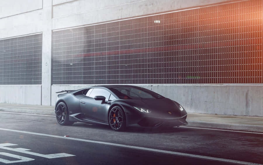 Sleek Black Sports Car Urban Backdrop Wallpaper