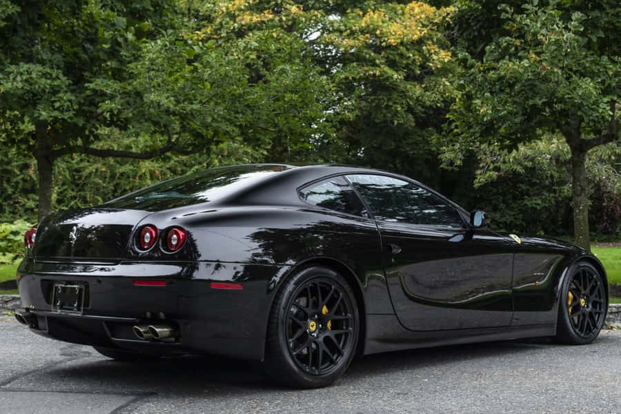 Sleek Ferrari 612 Scaglietti On A Scenic Coastal Road Wallpaper