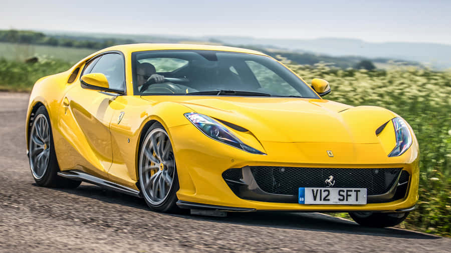Sleek Ferrari 812 Superfast In Motion On The Open Road. Wallpaper
