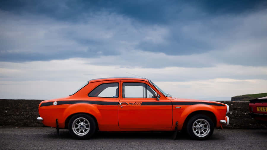 Sleek Ford Escort Cruising Down An Open Road Wallpaper