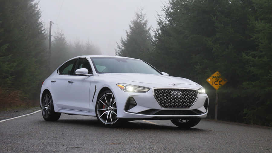 Sleek Genesis G70 Driving On Scenic Road Wallpaper