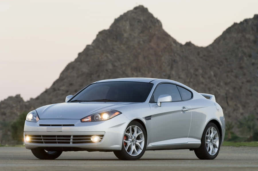 Sleek Hyundai Tiburon Racing On An Open Road Wallpaper