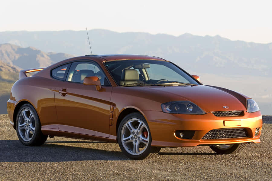 Sleek Hyundai Tiburon Sports Car On Scenic Road Wallpaper