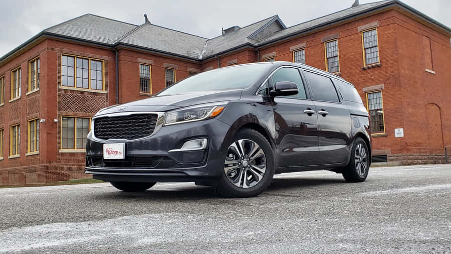 Sleek Kia Sedona In A Beautiful Cityscape Wallpaper