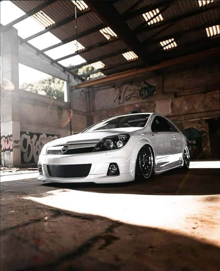 Sleek Opel Astra In Motion On A Picturesque Road Wallpaper