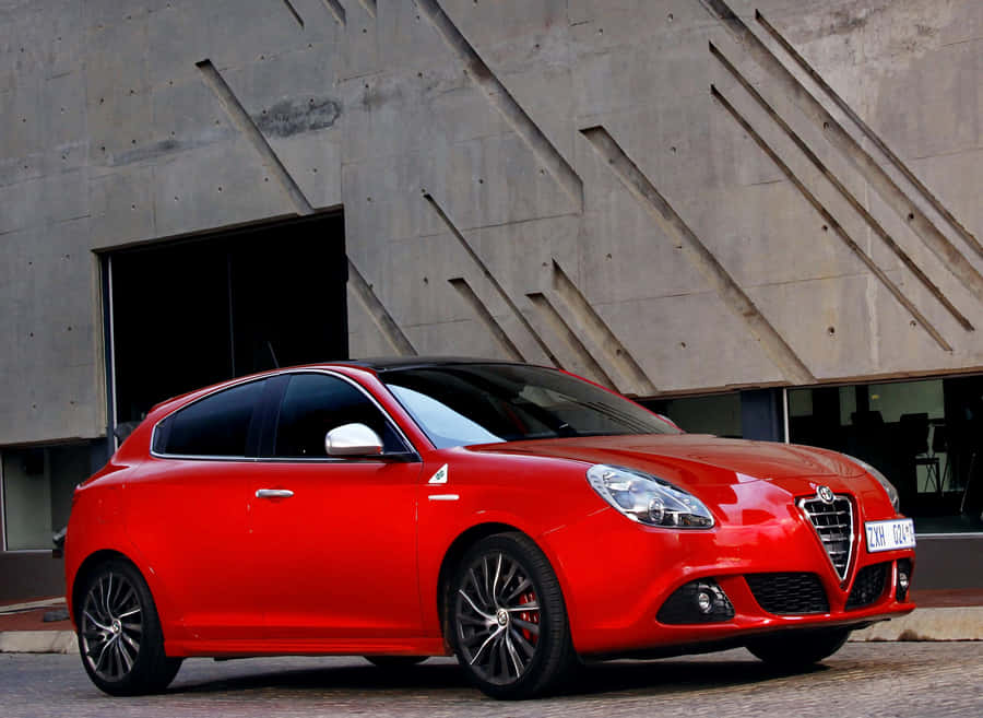 Sleek Red Alfa Romeo Giulietta In Action Wallpaper
