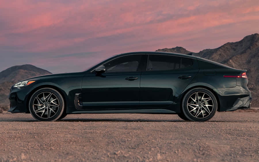 Sleek Red Kia Stinger On Open Road Wallpaper