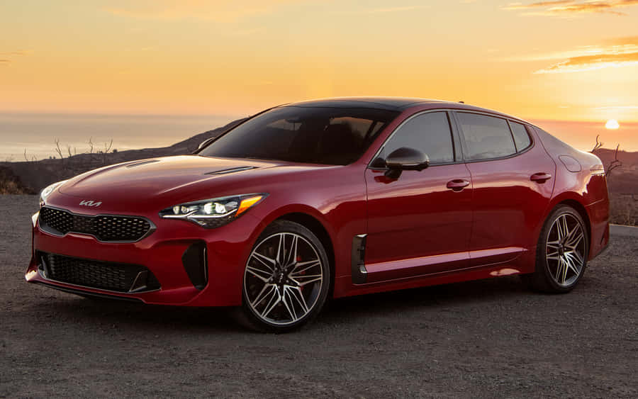 Sleek Red Kia Stinger On The Road Wallpaper
