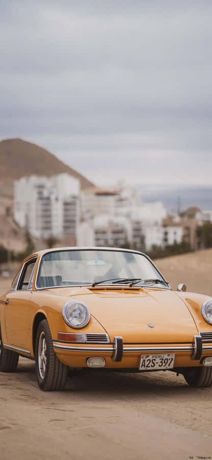 Sleek Retro Car Parked In An Industrial Area. Wallpaper