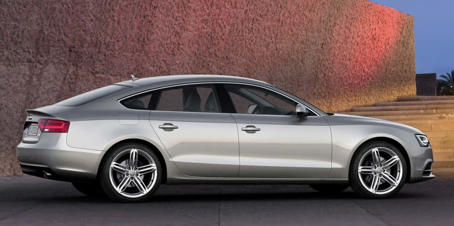 Sleek Silver Audi A5 On A Scenic Road Wallpaper