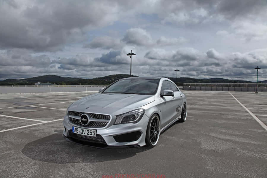 Sleek Silver Mercedes Benz Cla-class Parked On The City Street. Wallpaper