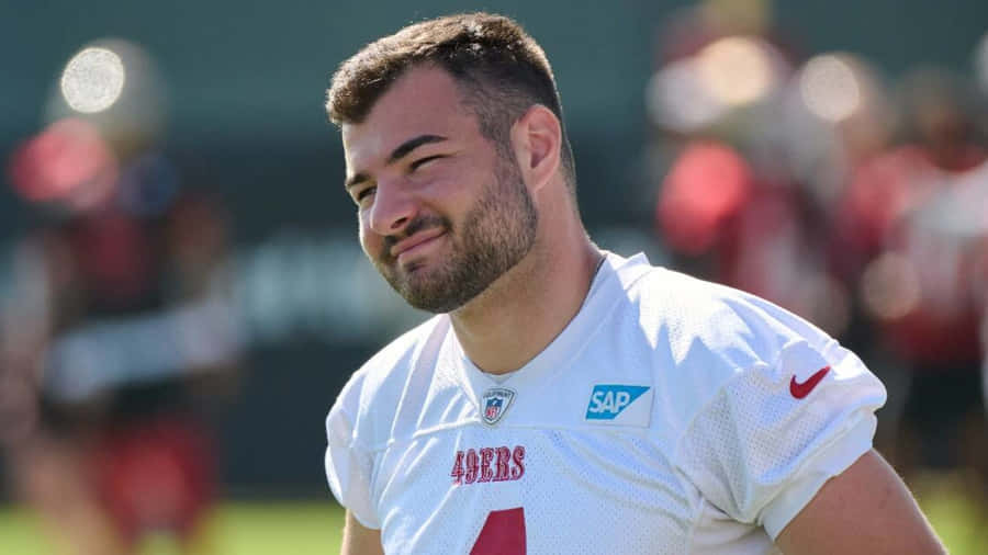 Smiling Football Player Outdoors Wallpaper