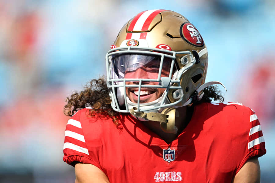 Smiling Football Playerin Red Uniform Wallpaper