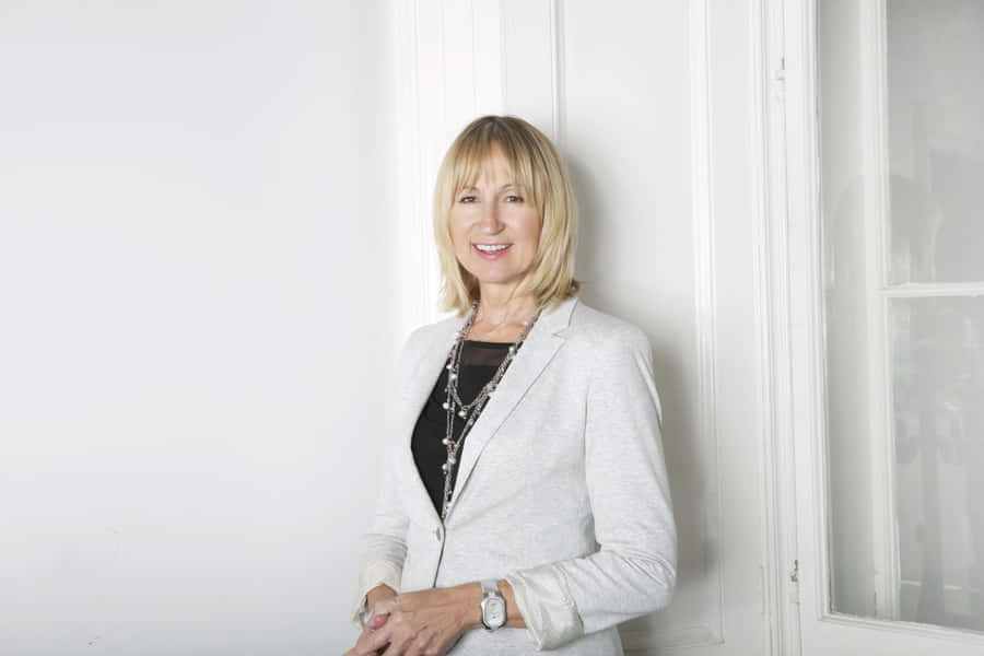 Smiling Woman Leaning Against White Wall Wallpaper