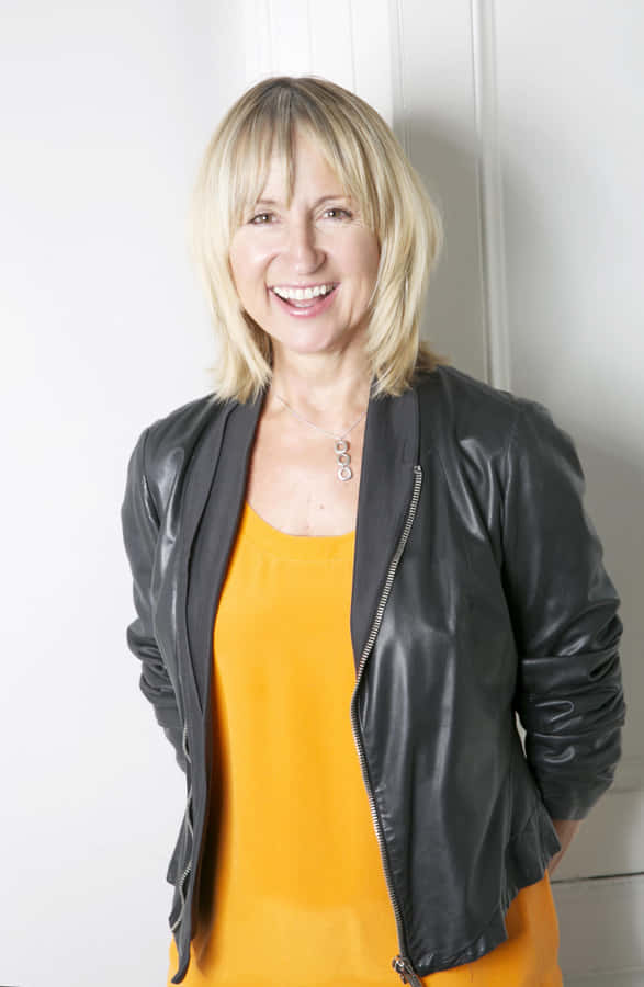 Smiling Womanin Yellow Topand Leather Jacket Wallpaper