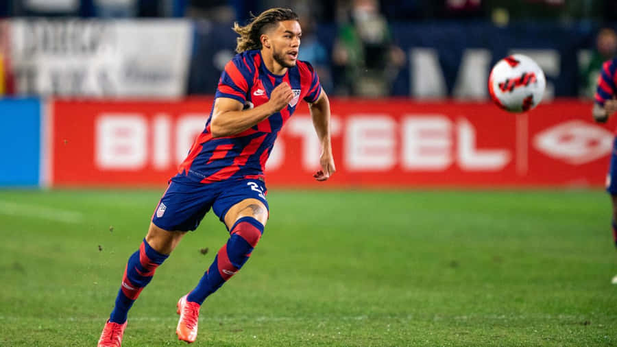 Soccer_ Player_ In_ Action_ On_ Field.jpg Wallpaper