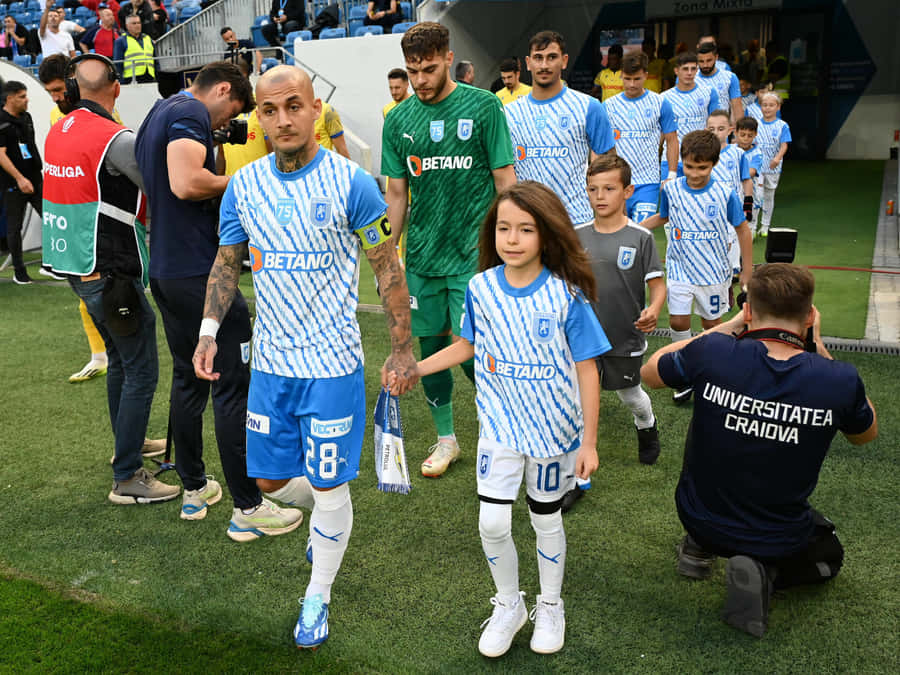 Soccer Playersand Children Walkingon Field Wallpaper