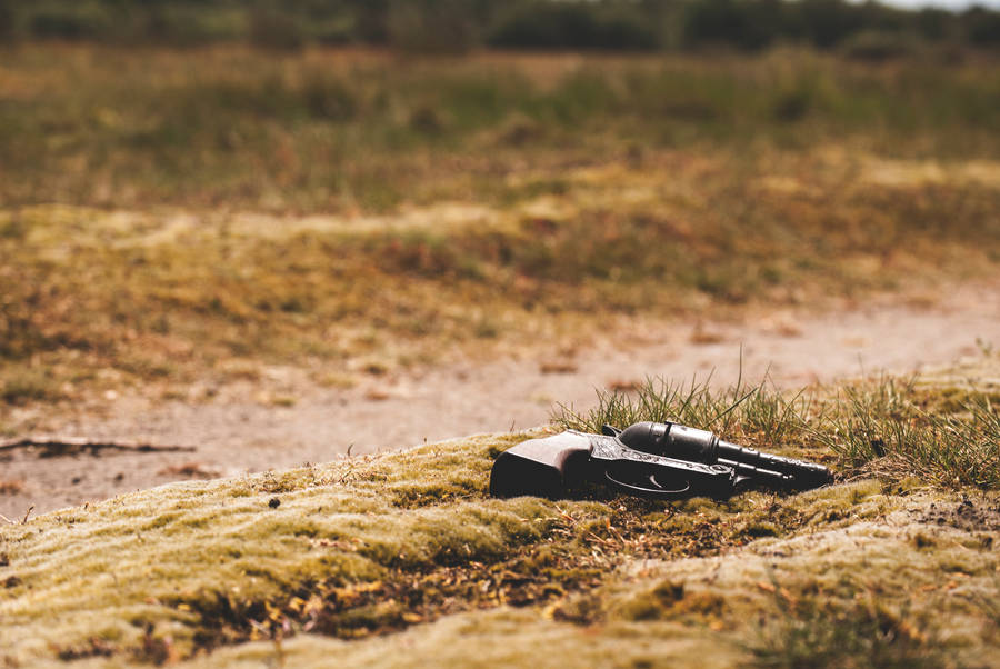 Solitary Revolver Resting On Rough Terrain Wallpaper