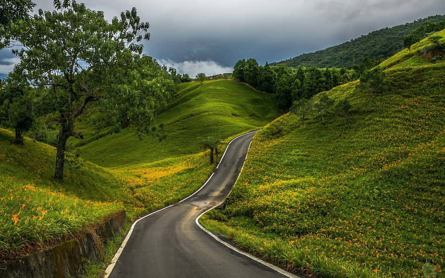 Spectacular Journey Through Country Road Surrounded By Hills Wallpaper
