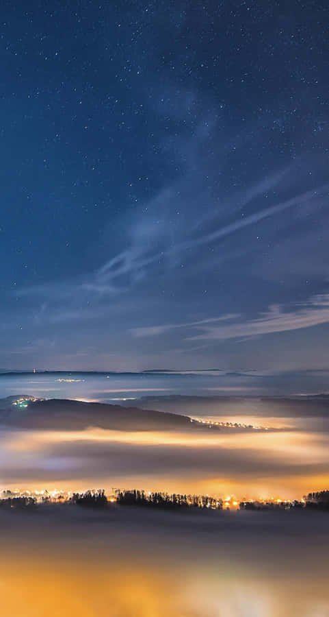 Starry Night Over Misty Landscape Wallpaper