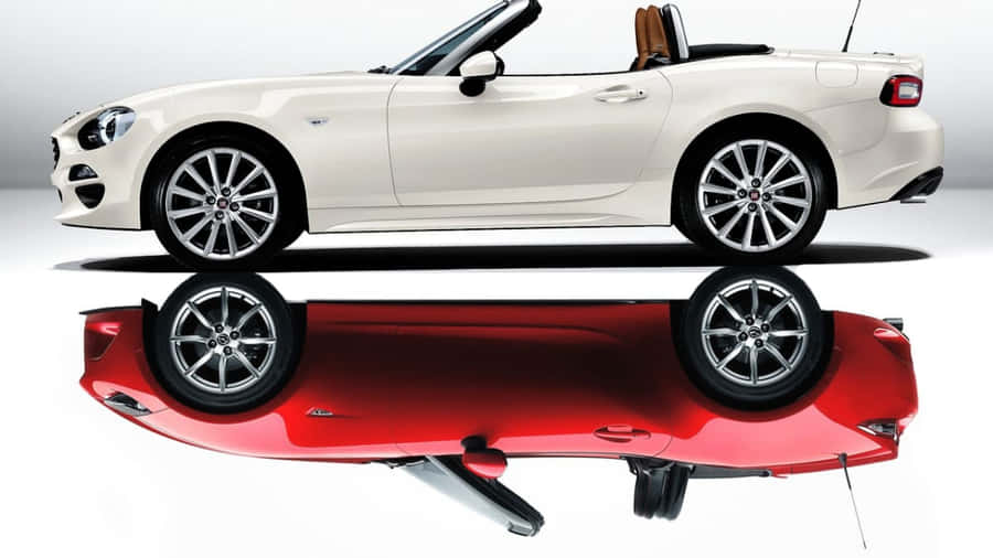 Stunning Fiat 124 Spider On A Scenic Road Wallpaper