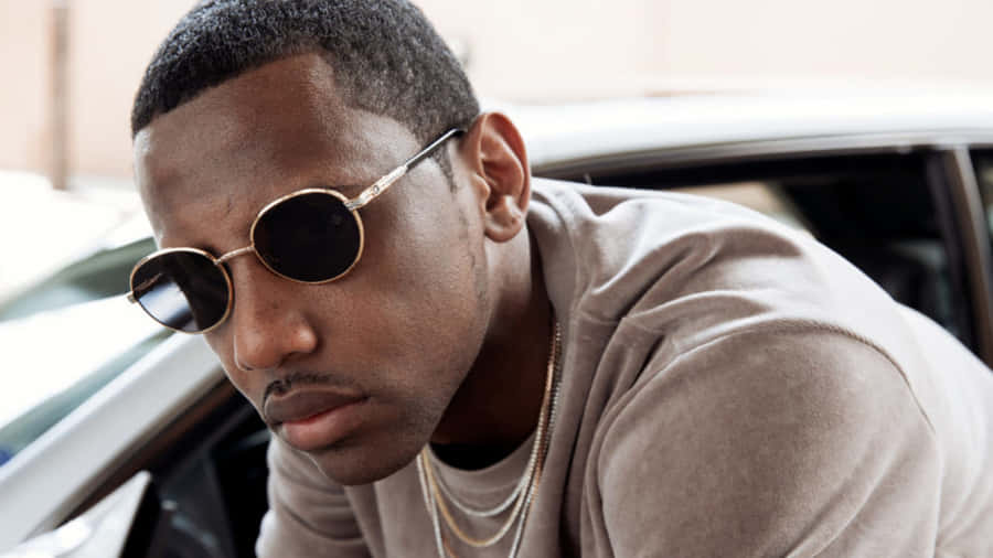 Stylish Manwith Sunglasses Leaningon Car Wallpaper