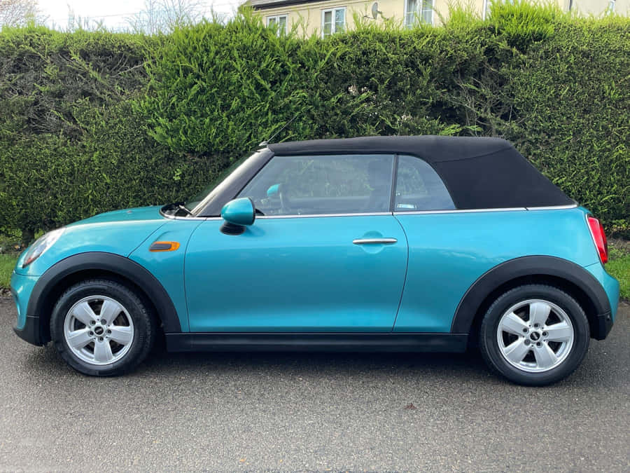 Stylish Mini Cooper Convertible Cruising On The Road Wallpaper