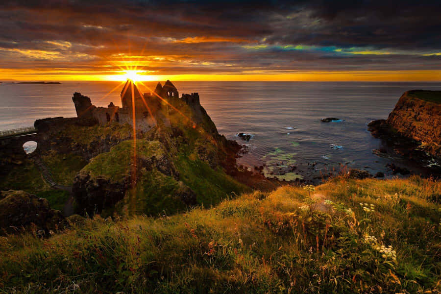 Sunset Through Dunluce Castle In Northern Ireland Wallpaper