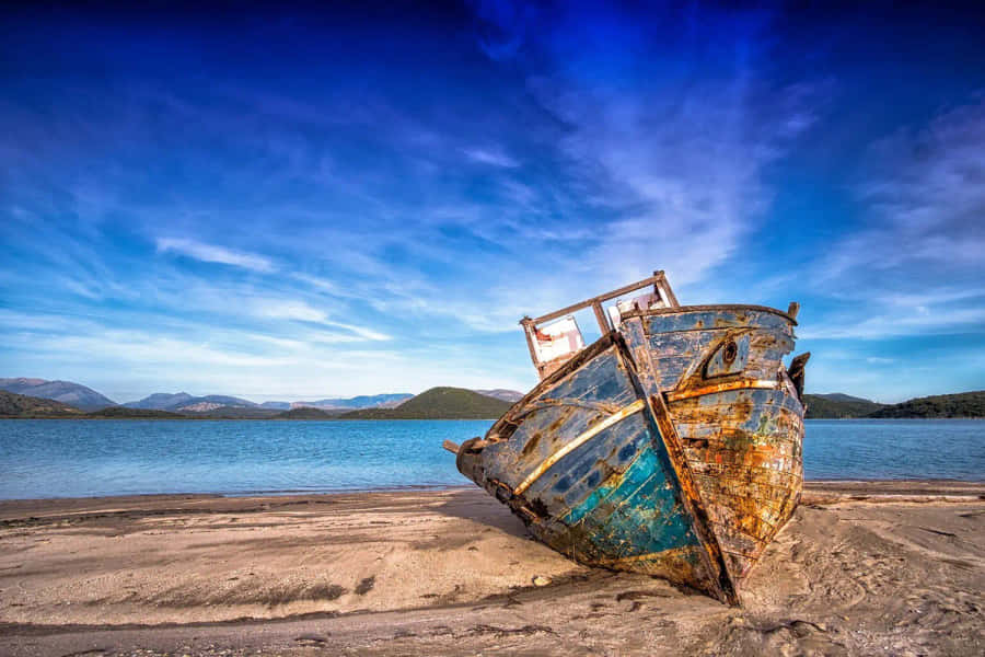 The Aging Beauty Of Isolation - A Rusty Boat Stranded Ashore Wallpaper