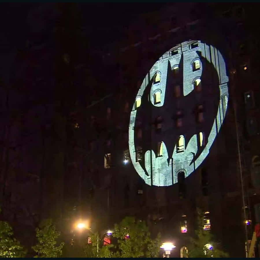 The Iconic Bat Signal Illuminating The Night Sky Wallpaper