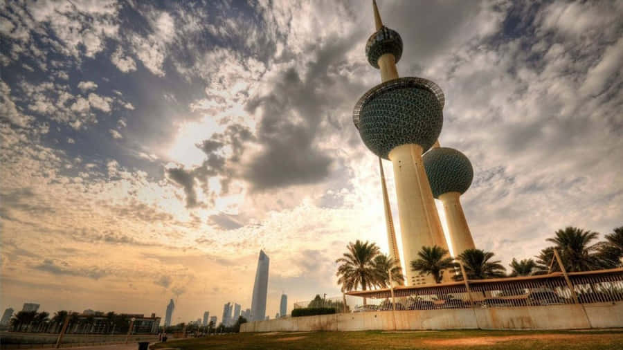 The Majestic Kuwait Towers Under A Magnificently Cloudy Sky Wallpaper