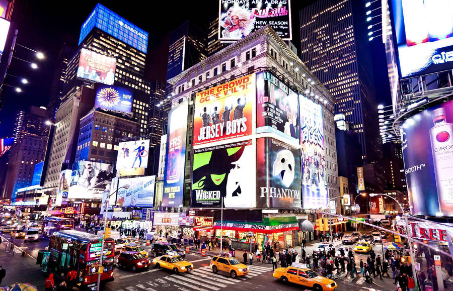Times Square At Night With Many People And Cars Wallpaper