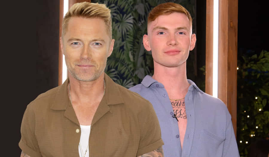 Two Men Standing Sideby Side Wallpaper