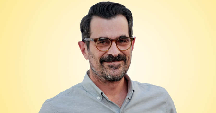 Ty Burrell Smiling On A Blue Background Wallpaper