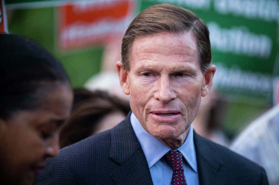 U.s. Senator Richard Blumenthal Standing In Front Of A Green Sign. Wallpaper