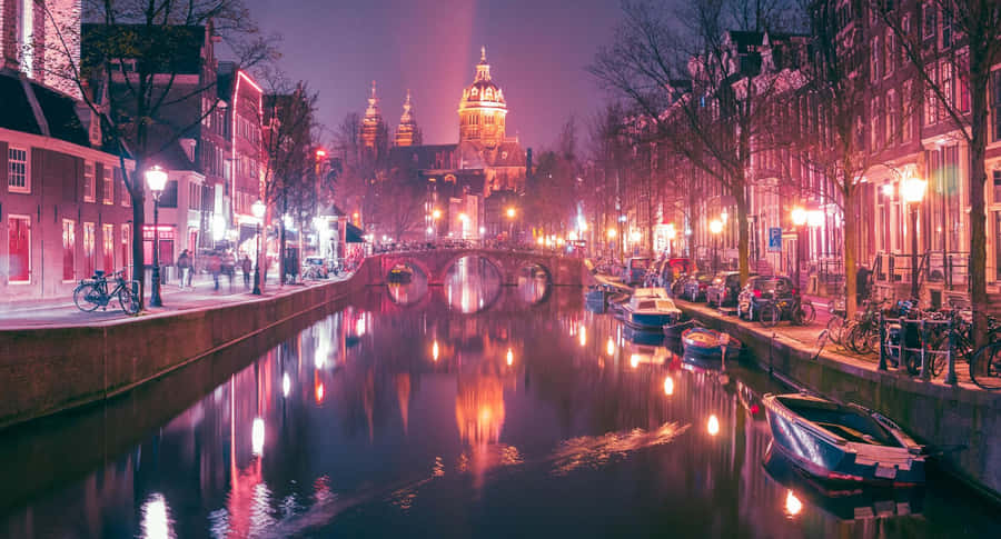 Vibrant Night Scene Of The Iconic Red Light District In Amsterdam Wallpaper