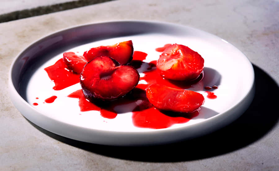 Vibrant Red Plum On A Branch Wallpaper