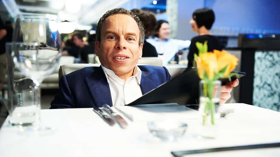 Warwick Davis Smiling And Posing For The Camera Wallpaper