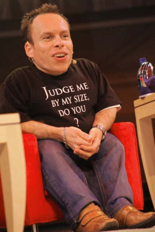 Warwick Davis Smiling And Wearing A Suit Wallpaper